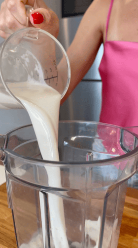 Almond milk being poured into a blender